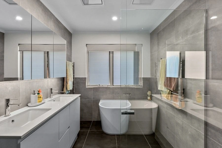 Modern grey bathroom renovation with double vanity sinks.