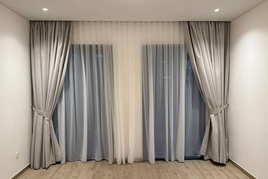 Grey blackout curtains with white sheer fabric.