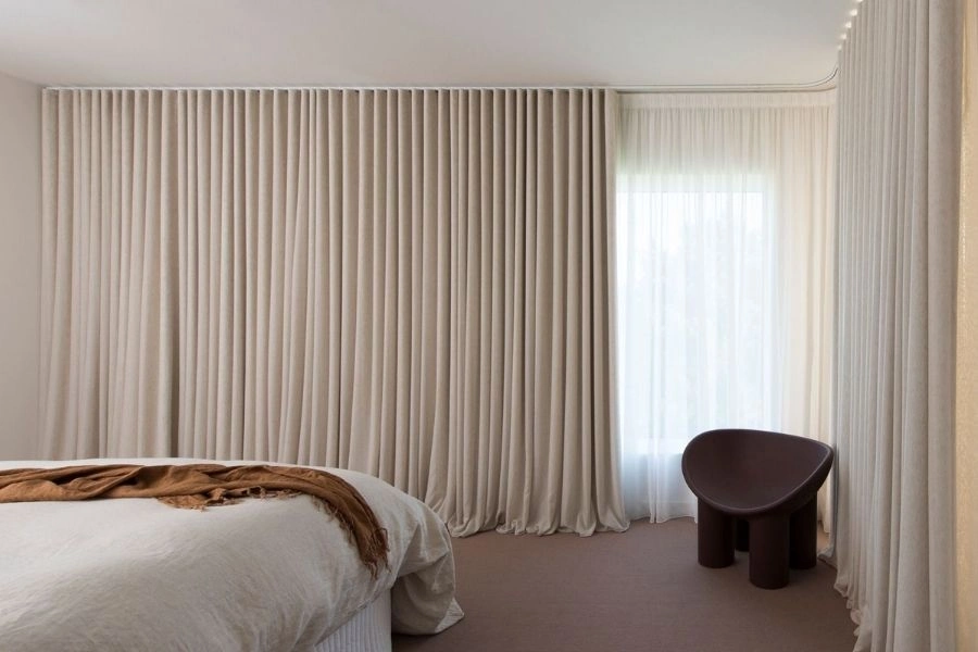 Beige wave fold curtains for bedroom window decor.