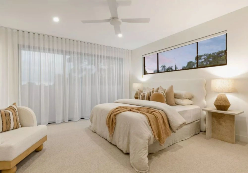 Luxury bedroom renovation with custom white sheer curtains.