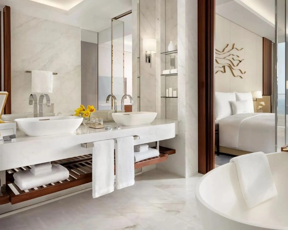 Luxury hotel bathroom renovation with open bedroom view.