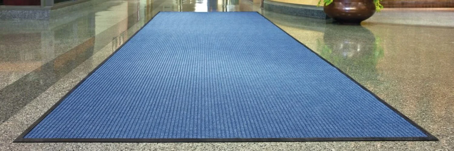 Long blue commercial runner floor mat in hallway.