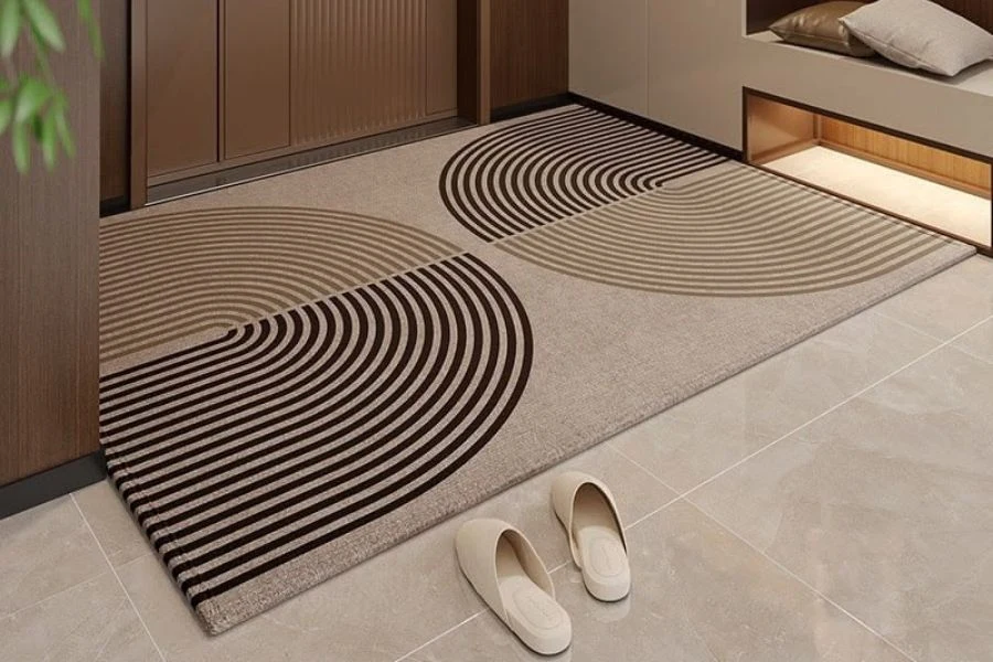 Modern entrance floor mat with a beige and brown semicircular geometric pattern.