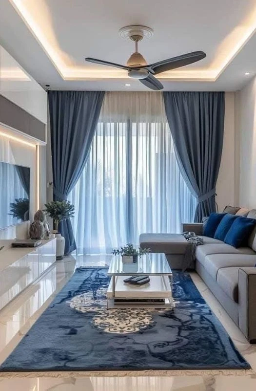 Luxury blue traditional rug with white floral patterns in a modern living room.