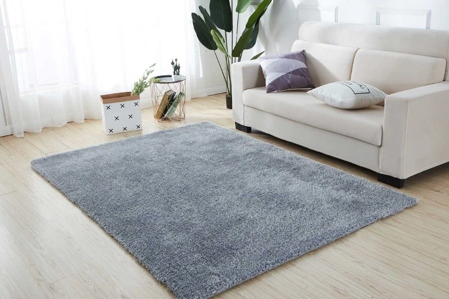 Soft grey shaggy rug placed on wooden floor.