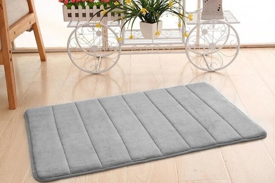 Grey plush memory foam floor mat on a light wooden floor.