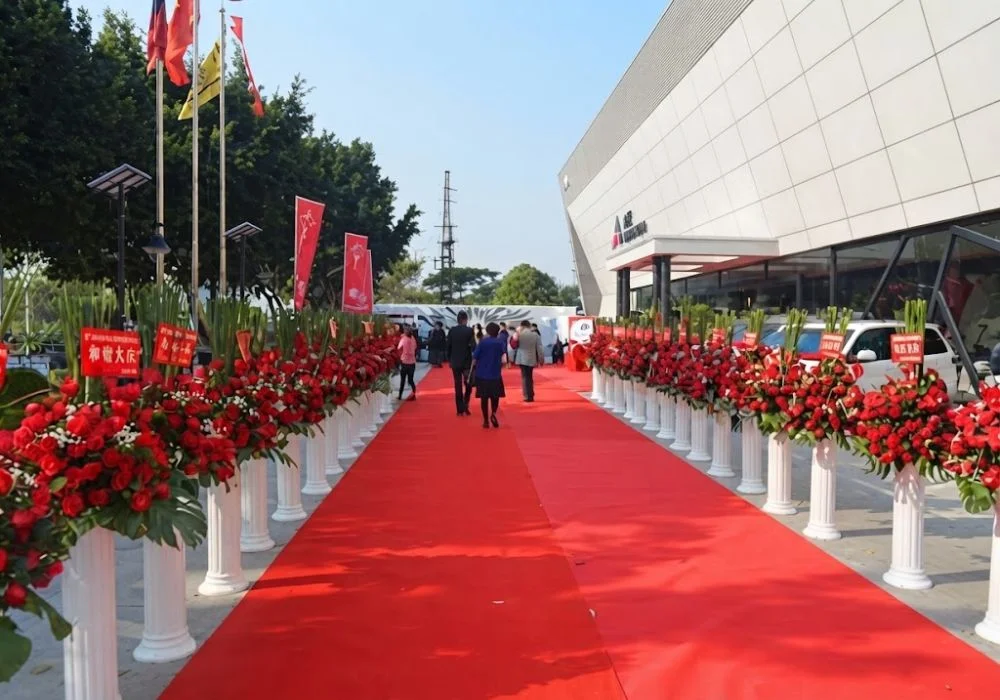 Outdoor red carpet path with event staff