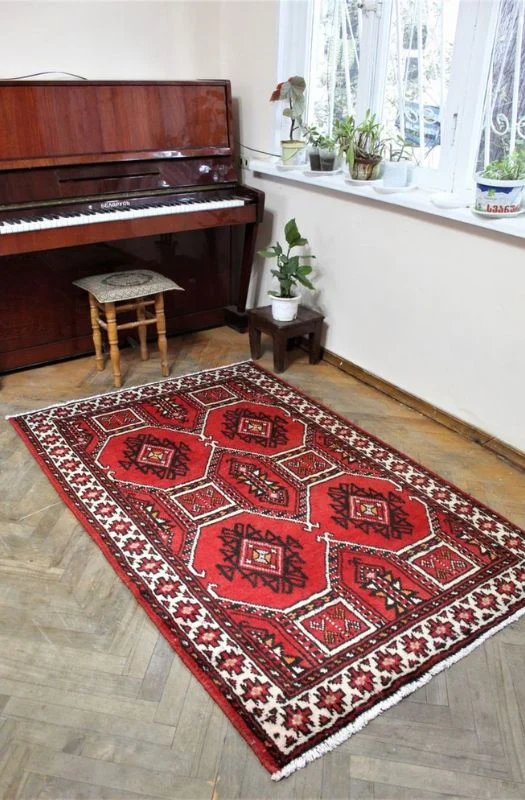 Red geometric Persian carpet near piano